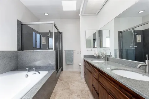 a spacious bathroom with a granite countertop sink mirror and bathtub
