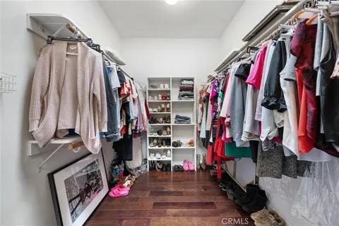 a view of walk in closet with clothes and shoes