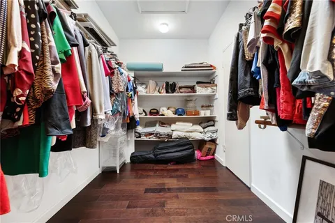 a view of walk in closet with clothes and shoes