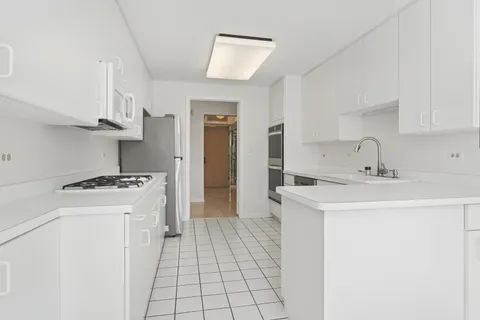 a kitchen with white cabinets and white appliances