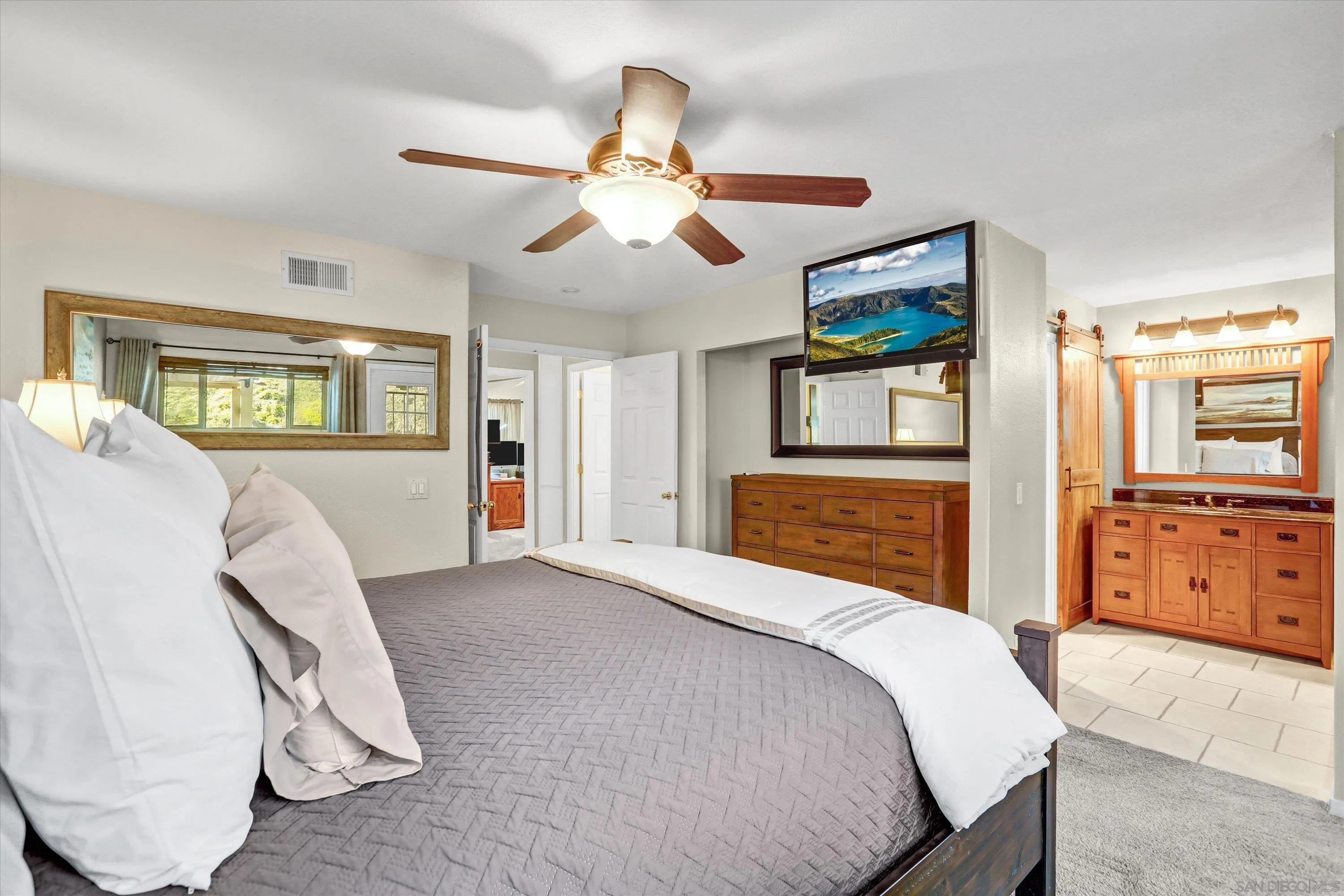 9448 Palomino Ridge Drive Lakeside, CA 92040 - Photo 21 of 35 a bedroom with a large bed and a chandelier