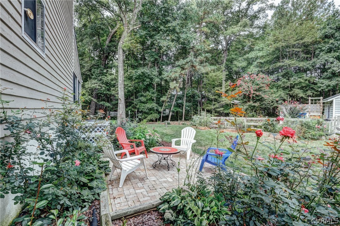 14117 Ridge Creek Road Midlothian, VA 23112 - Photo 21 of 24 a backyard of a house with table and chairs and wooden fence