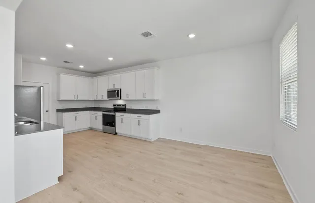a kitchen with stainless steel appliances granite countertop a refrigerator and a stove top oven