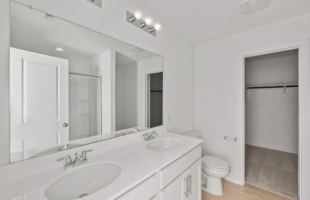 a bathroom with a toilet a sink a mirror and a shower