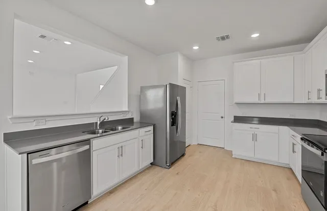 a kitchen with stainless steel appliances granite countertop a sink stove and refrigerator