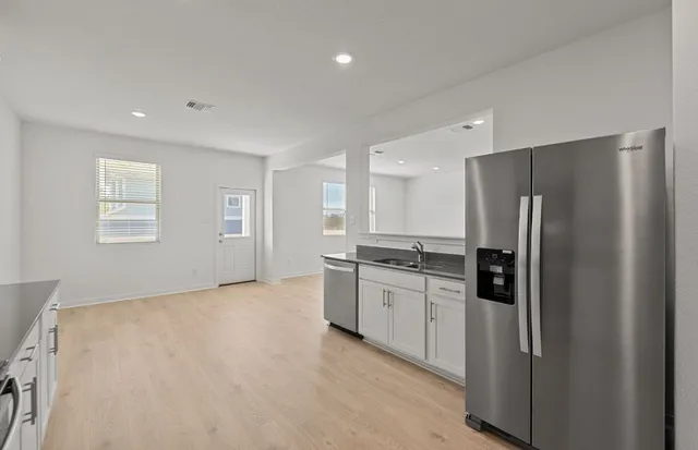 a kitchen with granite countertop white cabinets and stainless steel appliances