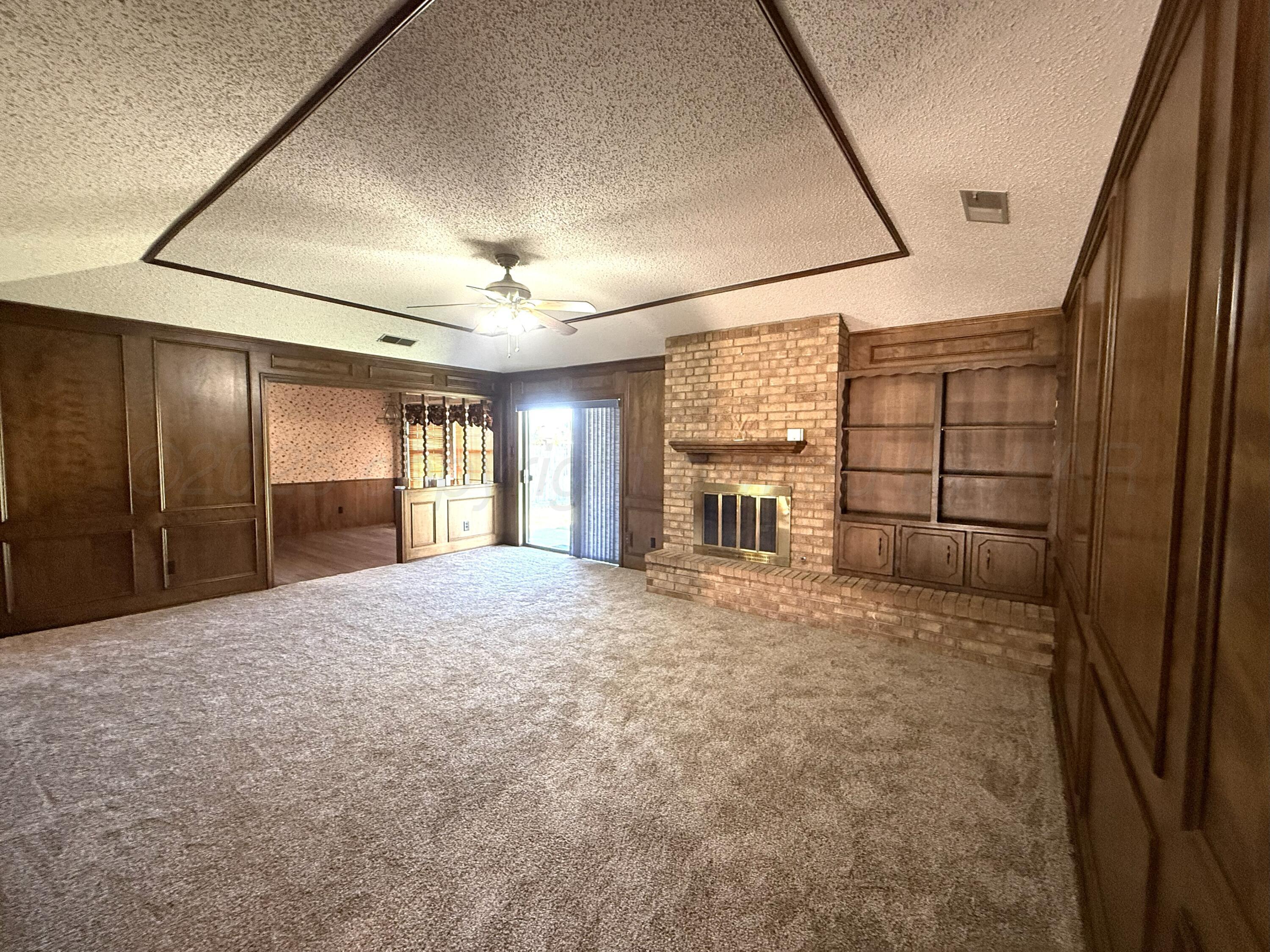 1525 North Nelson Street Pampa, TX 79065 - Photo 3 of 15 a view of empty room with windows and refrigerator