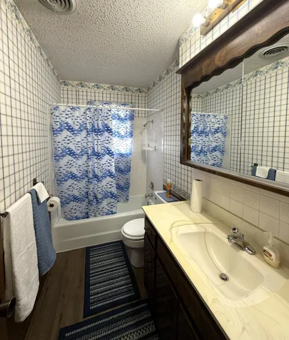 a bathroom with a granite countertop toilet sink and mirror