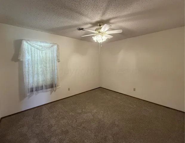 an empty room with a chandelier fan