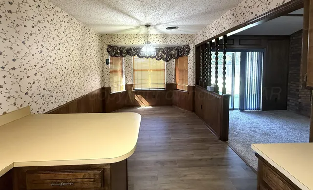 a large room with wooden floor and chandelier