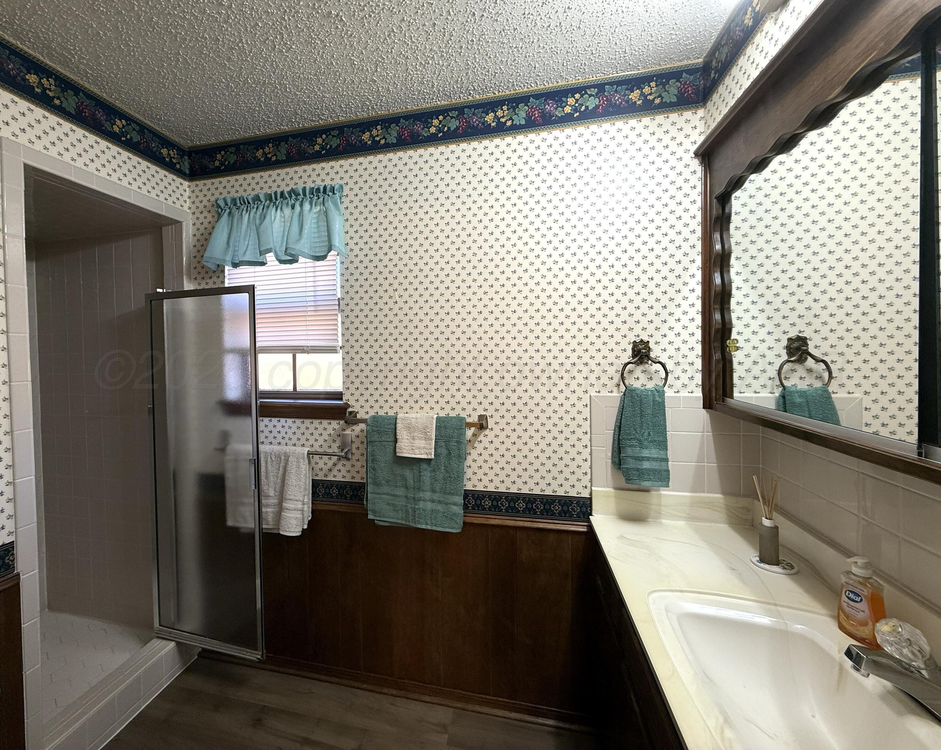 1525 North Nelson Street Pampa, TX 79065 - Photo 9 of 15 a bathroom with a sink and a mirror