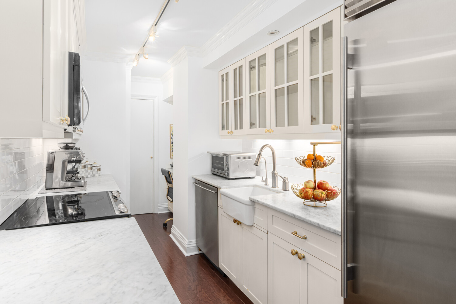 40 East 74th Street, Unit 1 Manhattan, NY 10021 - Photo 3 of 11 a kitchen with a sink stove and wooden cabinets