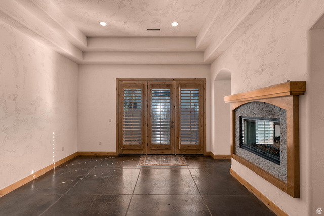 2464 East Granite Way St. George, UT 84790 - Photo 40 of 106 Formal dining room featuring a multi sided fireplace, french doors, a raised ceiling, and recessed lighting