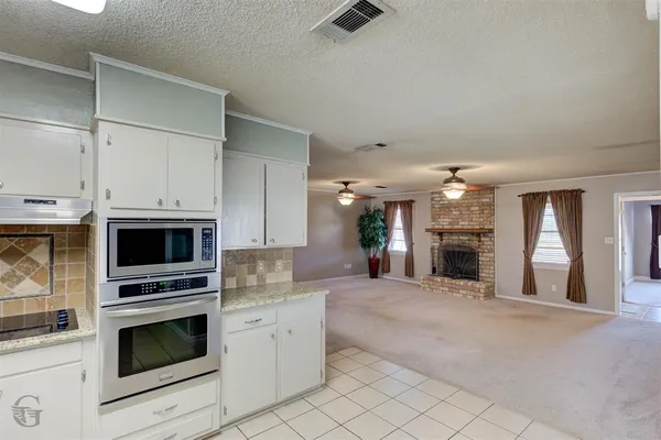 a kitchen with stainless steel appliances kitchen island granite countertop a stove and a sink with granite countertops