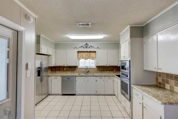 a kitchen with white cabinets appliances and a sink