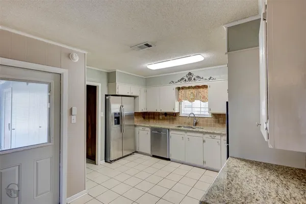 a kitchen with a sink a refrigerator and cabinets