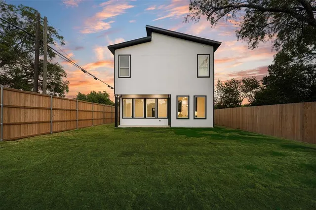 a view of backyard of house with green space