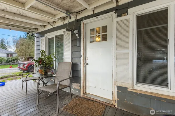 a view of a chairs and table in patio with a barbeque