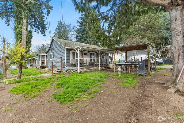 a view of a house with backyard and a tree