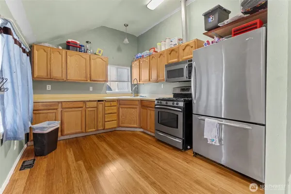 a kitchen with stainless steel appliances a stove a sink and a refrigerator