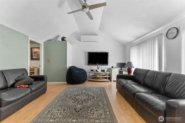 a living room with furniture a flat screen tv and a window