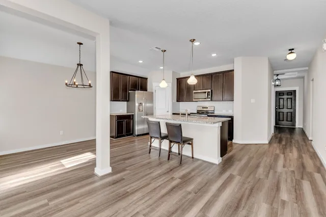 a kitchen with stainless steel appliances kitchen island wooden cabinets and granite counter tops