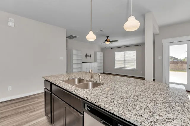 a kitchen with stainless steel appliances kitchen island granite countertop a refrigerator and a stove top oven