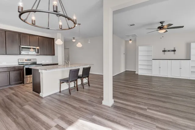 a view of kitchen with cabinets microwave and refrigerator