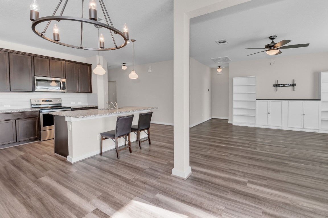 300 Colthorpe Lane Hutto, TX 78634 - Photo 15 of 36 a kitchen with stainless steel appliances granite countertop a white cabinets and stove top oven