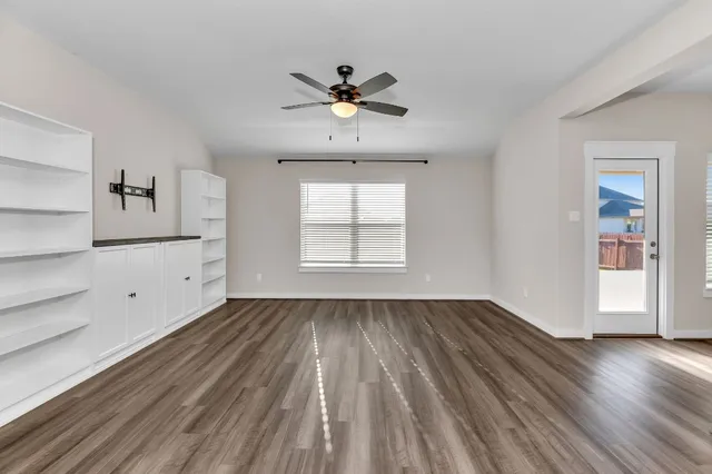 an empty room with a window and a fan