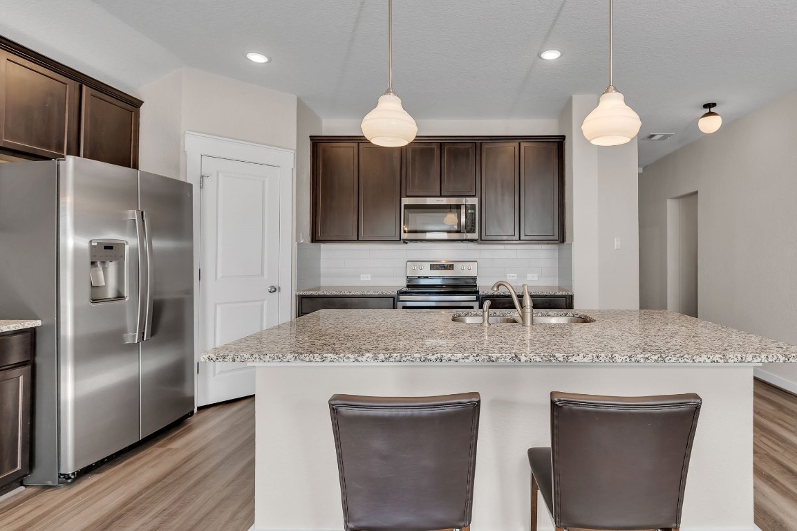 300 Colthorpe Lane Hutto, TX 78634 - Photo 8 of 36 a kitchen with kitchen island a counter space a sink appliances and cabinets