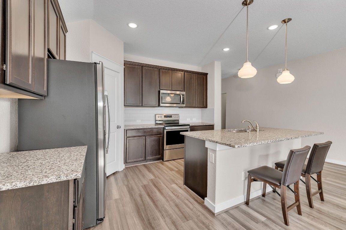 300 Colthorpe Lane Hutto, TX 78634 - Photo 9 of 36 a kitchen with a sink stainless steel appliances and cabinets