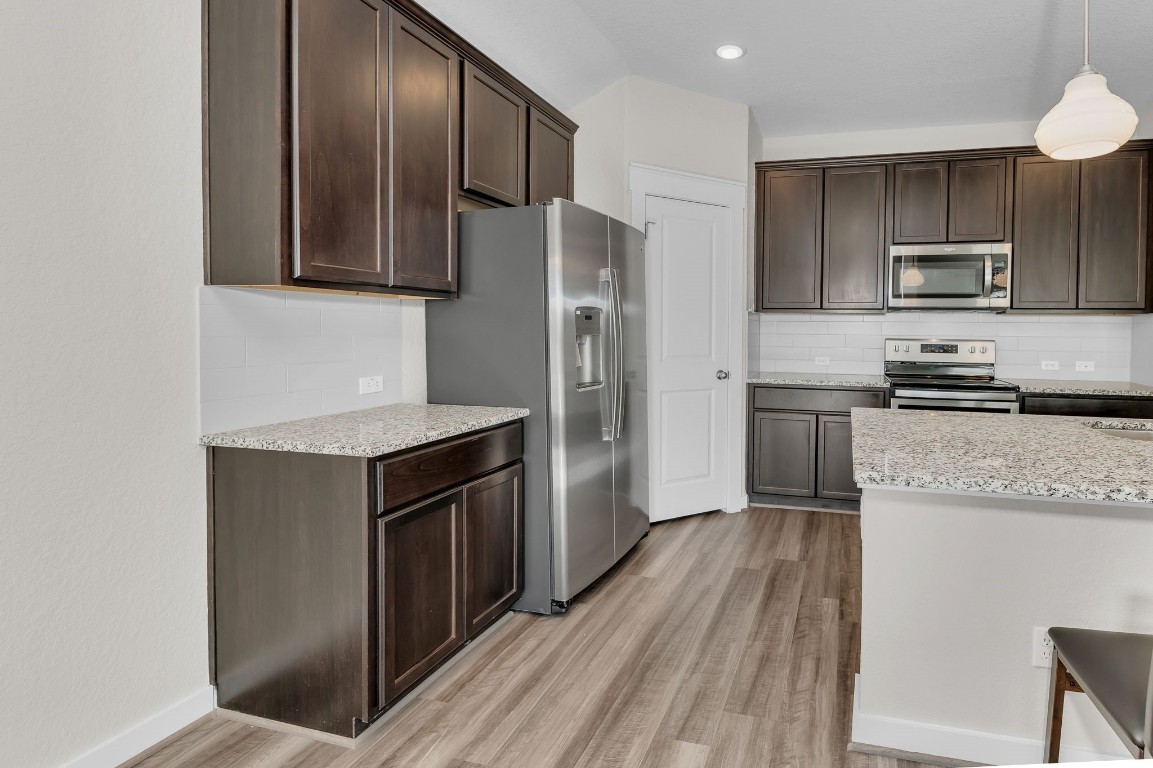 300 Colthorpe Lane Hutto, TX 78634 - Photo 10 of 36 a kitchen with stainless steel appliances granite countertop a refrigerator a stove top oven a sink and dishwasher
