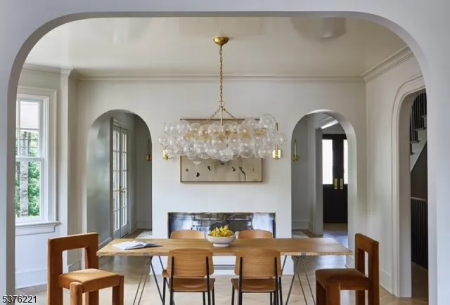 a view of a dining room with furniture a chandelier and wooden floor