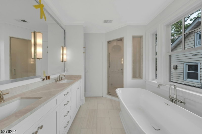 82 Watchung Avenue Montclair, NJ 07043 - Photo 29 of 48 a bathroom with a granite countertop double vanity sink a mirror and a bathtub