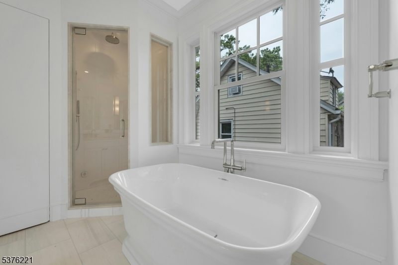 82 Watchung Avenue Montclair, NJ 07043 - Photo 30 of 48 a white bath tub sitting in a bathroom next to a window