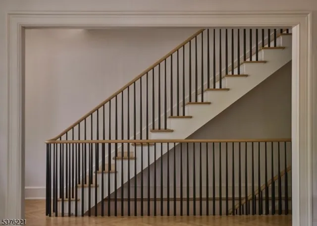 a view of staircase with railing and white walls