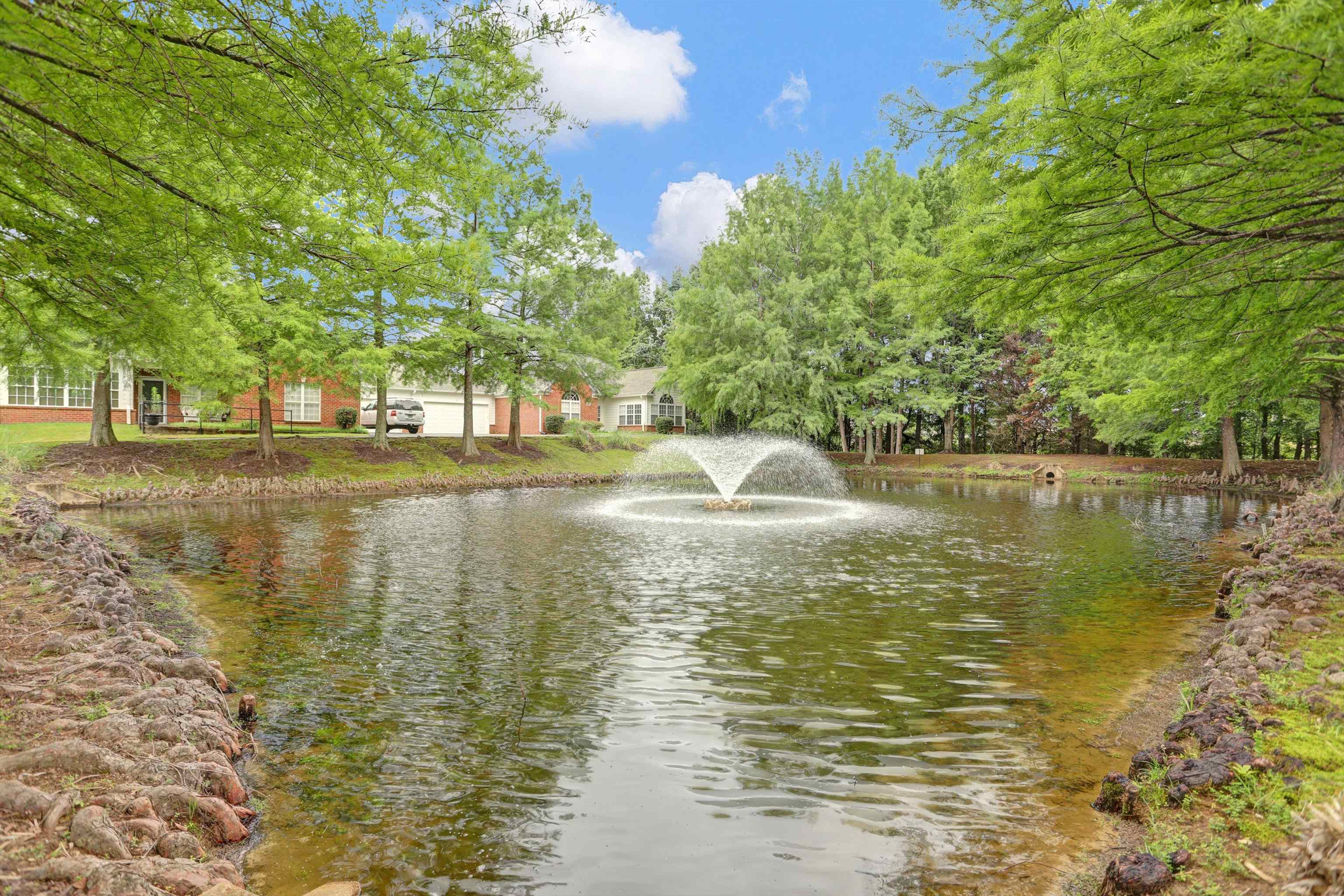 34 Peyton Ridge Drive, Unit 21 Collierville, TN 38017 - Photo 37 of 37 Pond featuring a central fountain, surrounded by mature trees and lush green landscaping