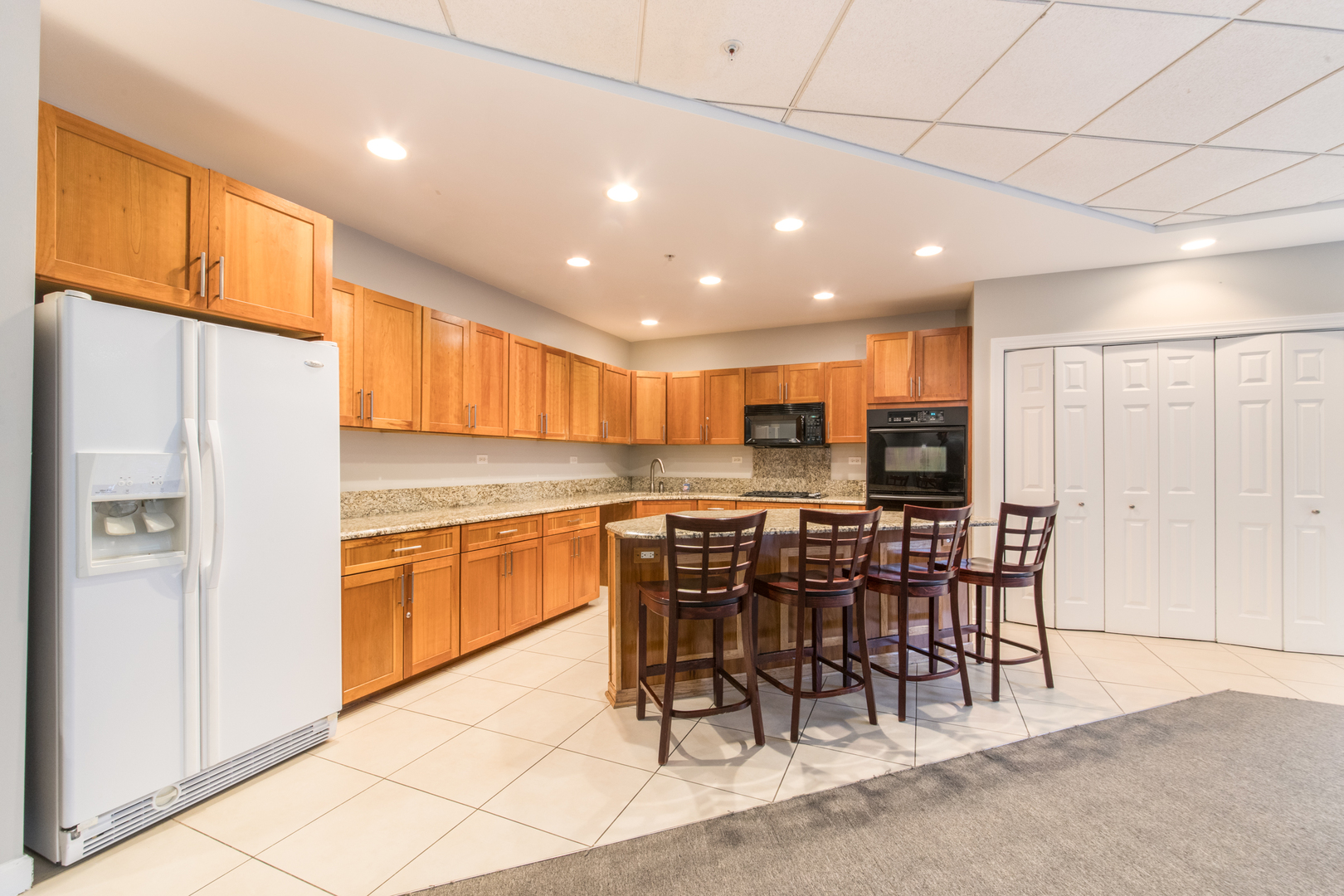 1 Renaissance Place, Unit 309 Palatine, IL 60067 - Photo 21 of 28 a kitchen with stainless steel appliances kitchen island granite countertop a refrigerator and cabinets