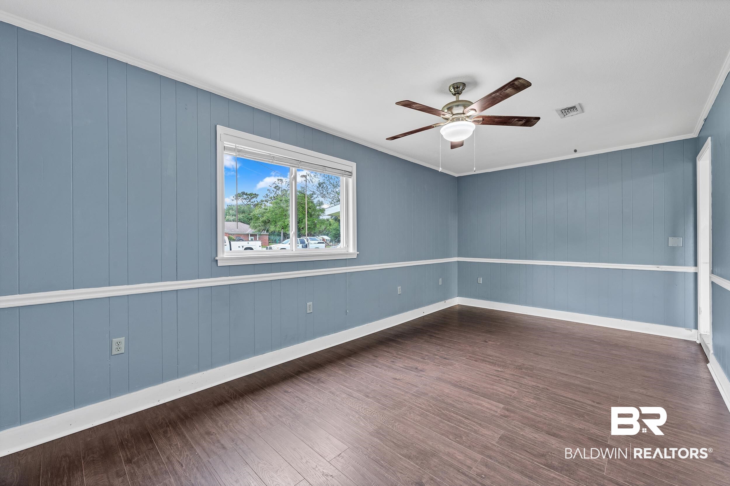 206 West Jackson Avenue Summerdale, AL 36580 - Photo 16 of 37 Unfurnished room featuring ceiling fan, dark wood-style flooring, ornamental molding, and baseboards