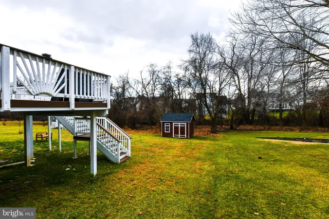 a view of swimming pool with lawn chairs and iron fence