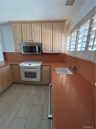 a kitchen with granite countertop a stove a sink and a microwave