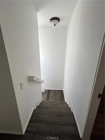 a view of a hallway with wooden floor and entryway