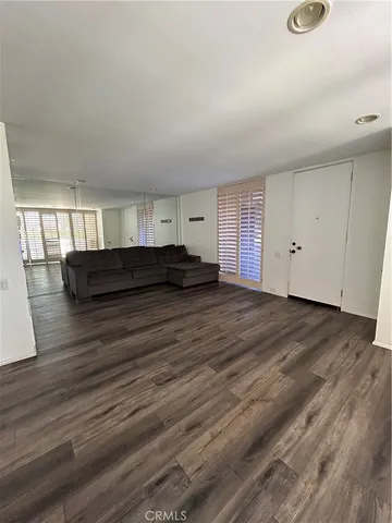 a spacious bedroom with a bed and wooden floor