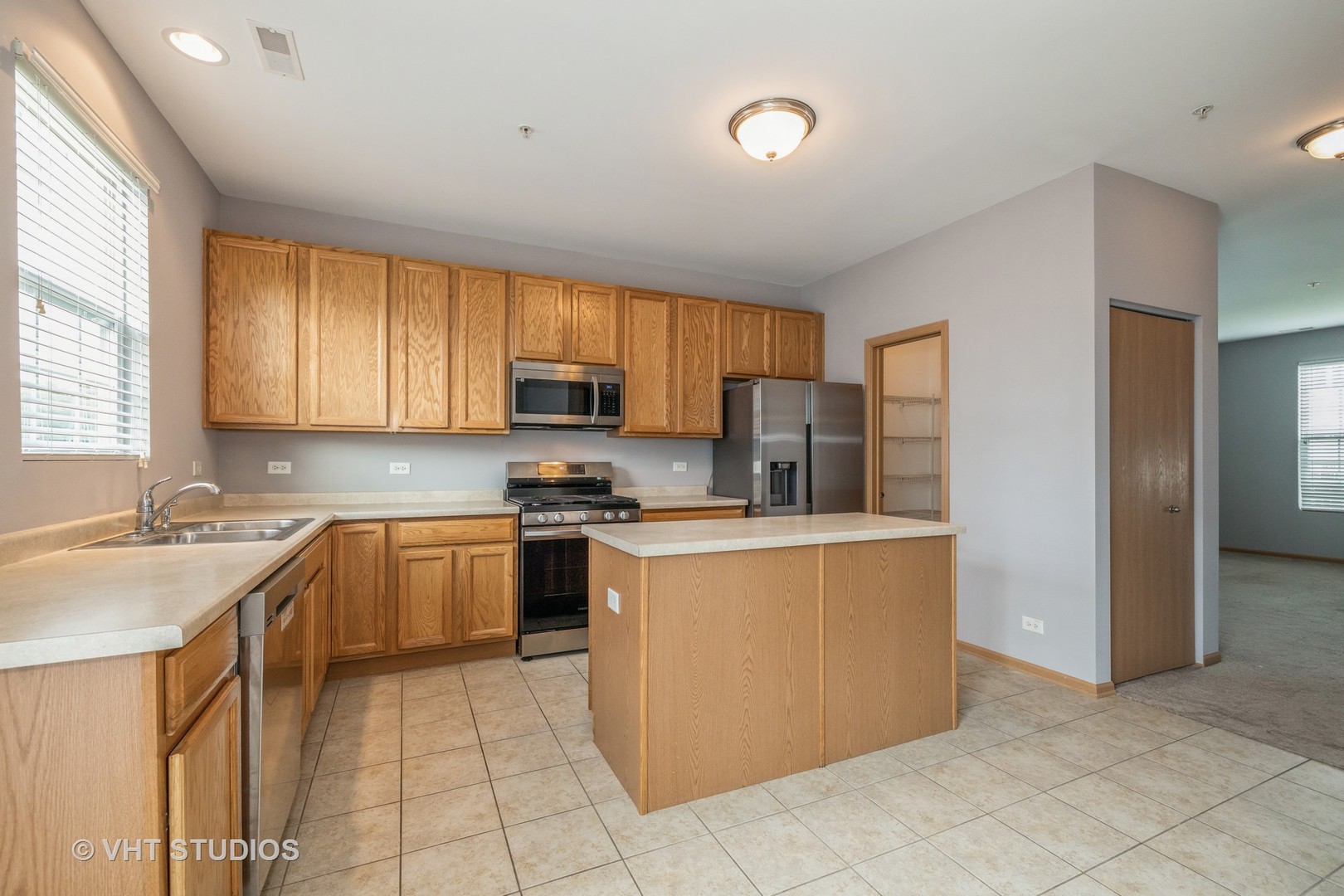 3781 Bailey Road, Unit 404 Yorkville, IL 60560 - Photo 16 of 21 a kitchen with stainless steel appliances granite countertop a stove top oven a sink a refrigerator and white cabinets