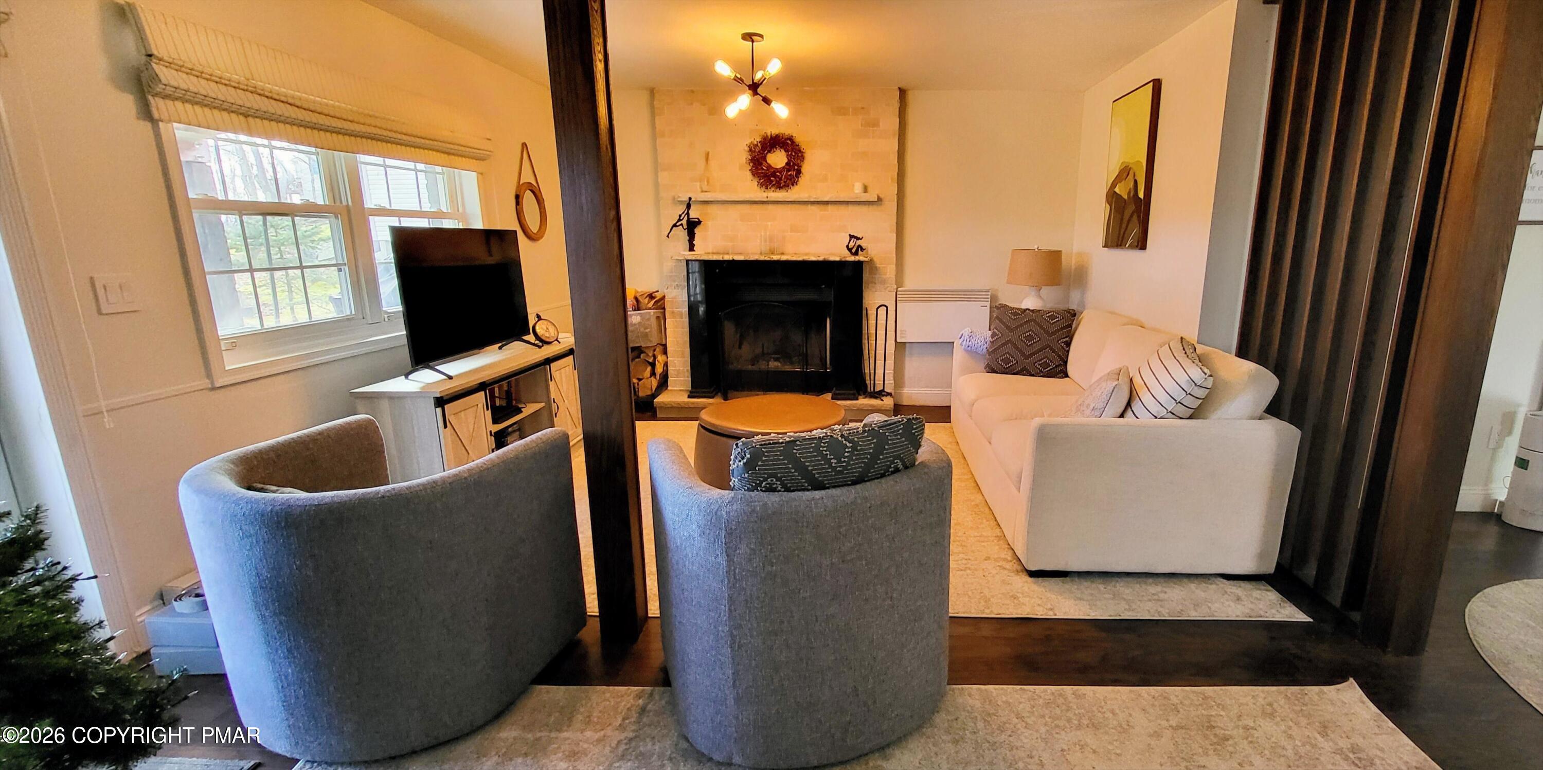 1093 Porter Drive Bushkill, PA 18324 - Photo 26 of 66 a living room with furniture a fireplace and a flat screen tv