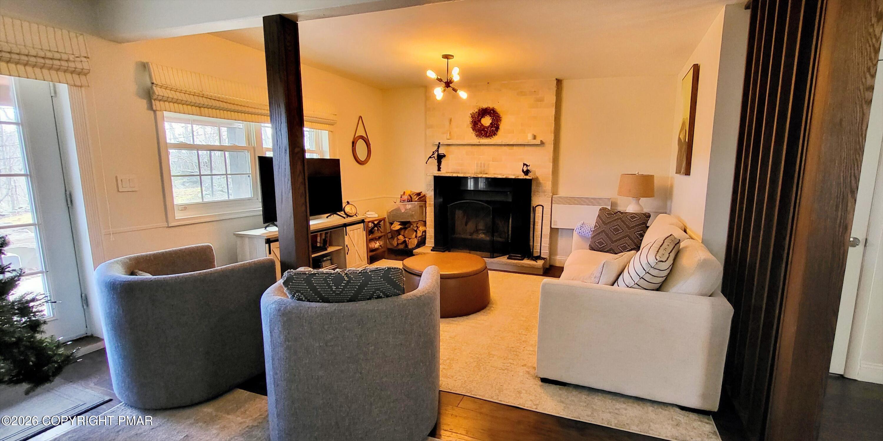 1093 Porter Drive Bushkill, PA 18324 - Photo 27 of 66 a living room with furniture a large window and a fireplace