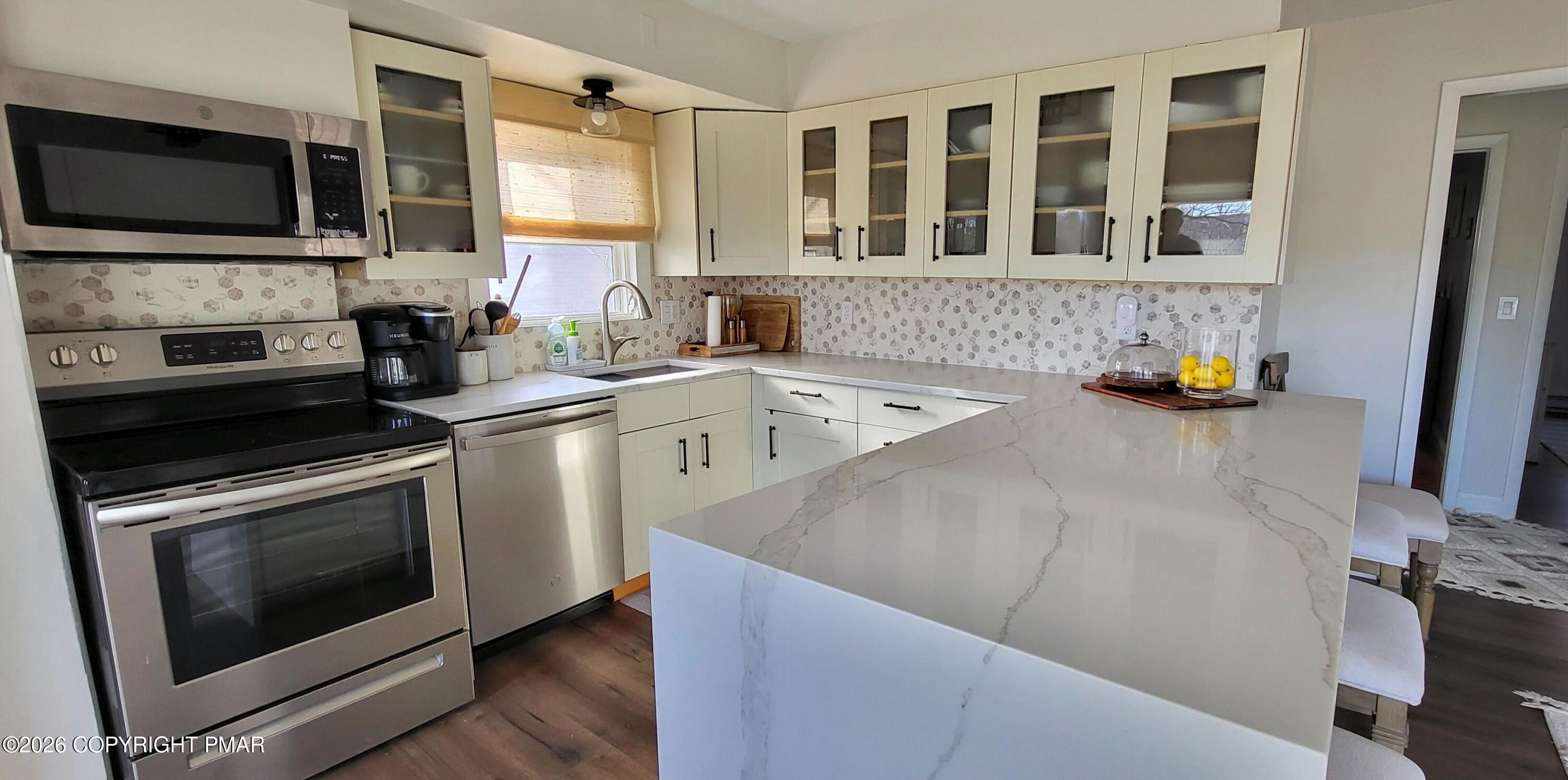 1093 Porter Drive Bushkill, PA 18324 - Photo 8 of 66 a kitchen with stainless steel appliances a stove microwave and refrigerator