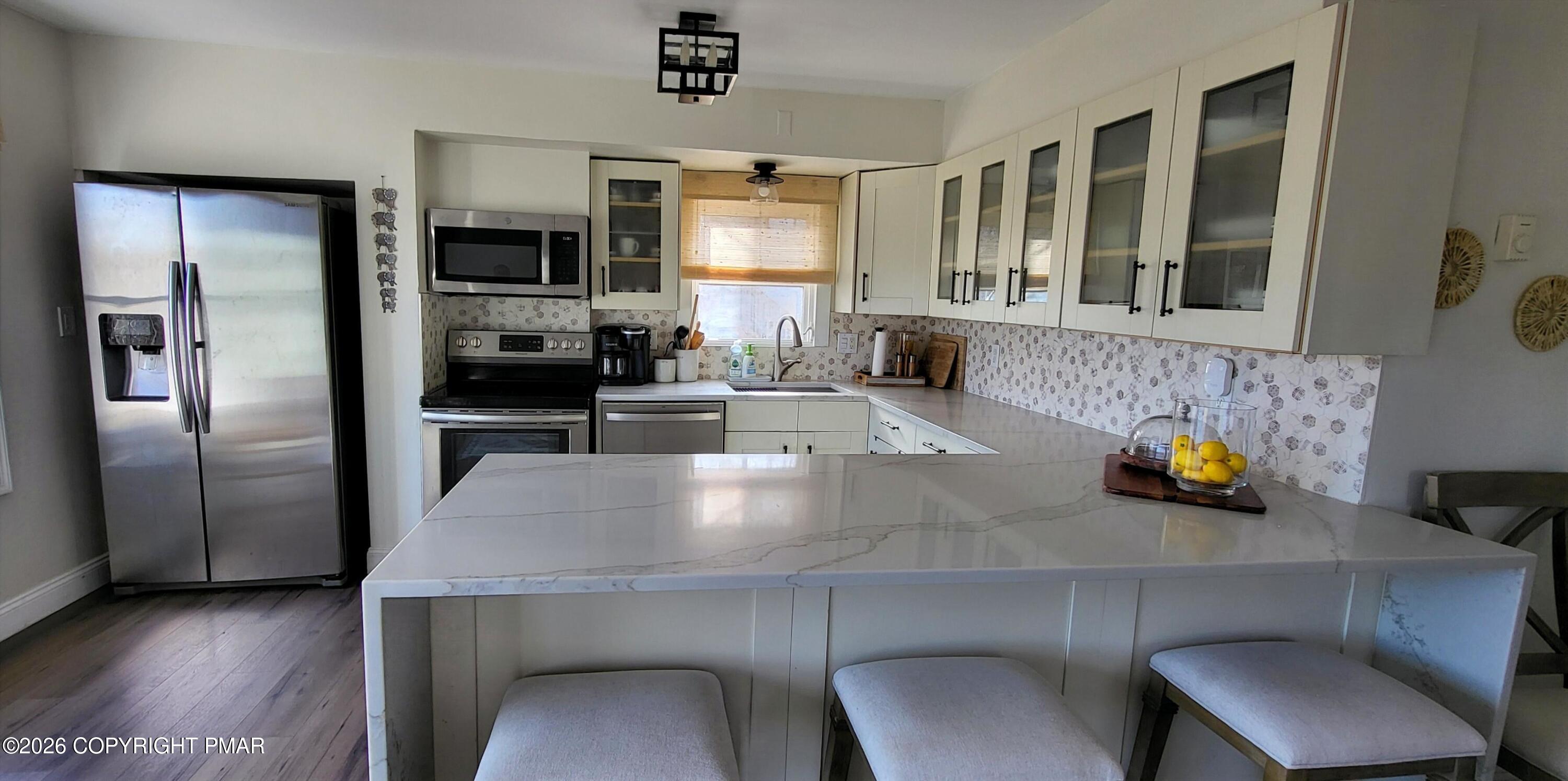 1093 Porter Drive Bushkill, PA 18324 - Photo 10 of 66 a kitchen with stainless steel appliances dining table and chairs