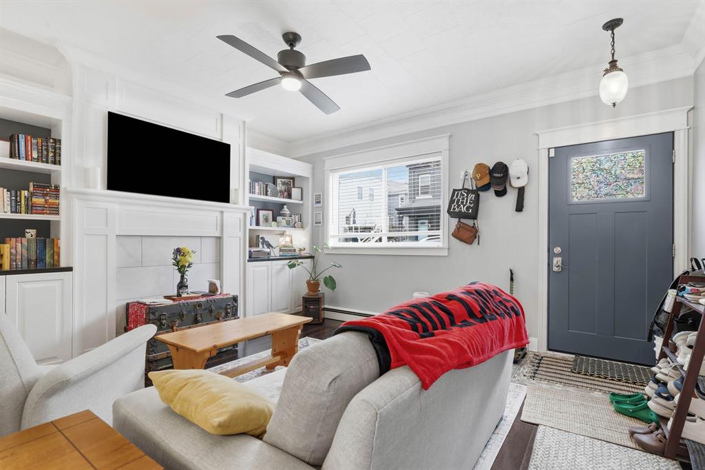 5133 Holmes Street Pittsburgh, PA 15201 - Photo 12 of 45 Living room features decorative fireplace and built in shelves with lighting as well as a ceiling fan